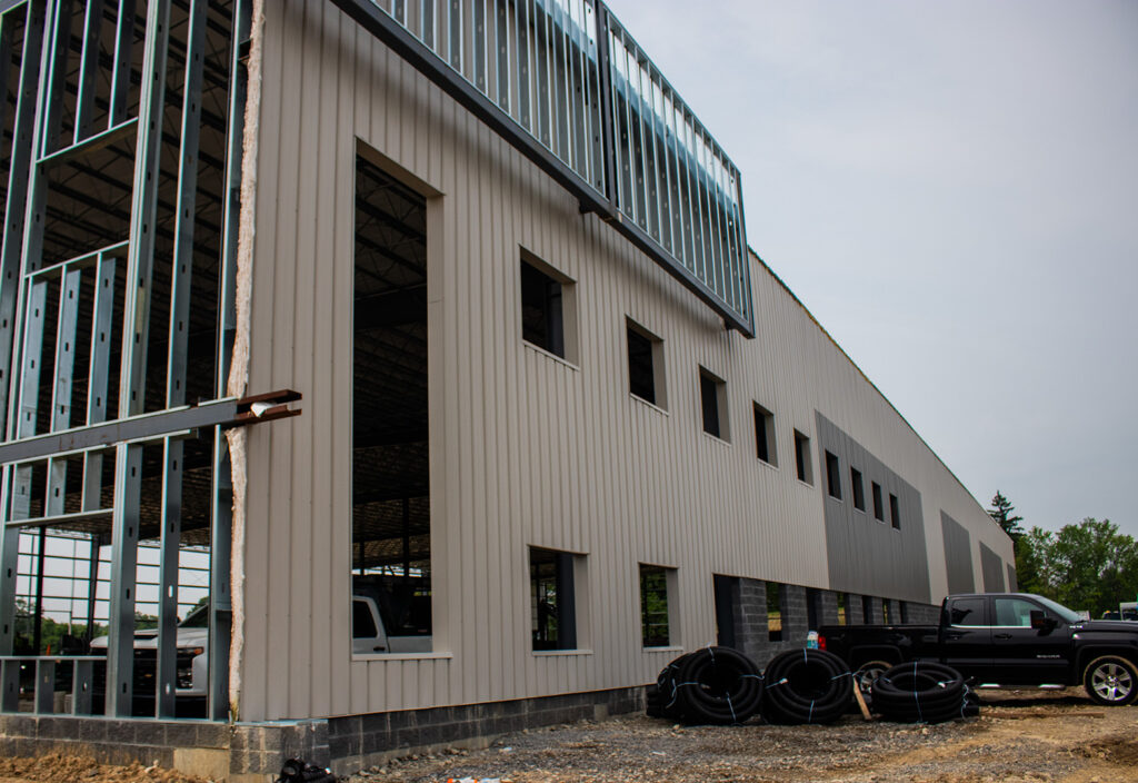 Warehouse in the process of being built with parking lot and cars