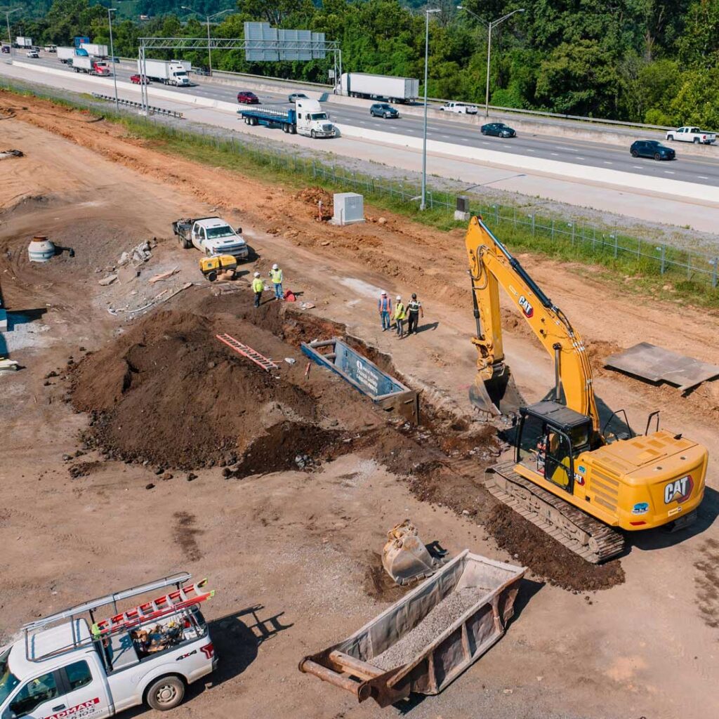 Drone footage of a large excavator digging hole in ground for construction