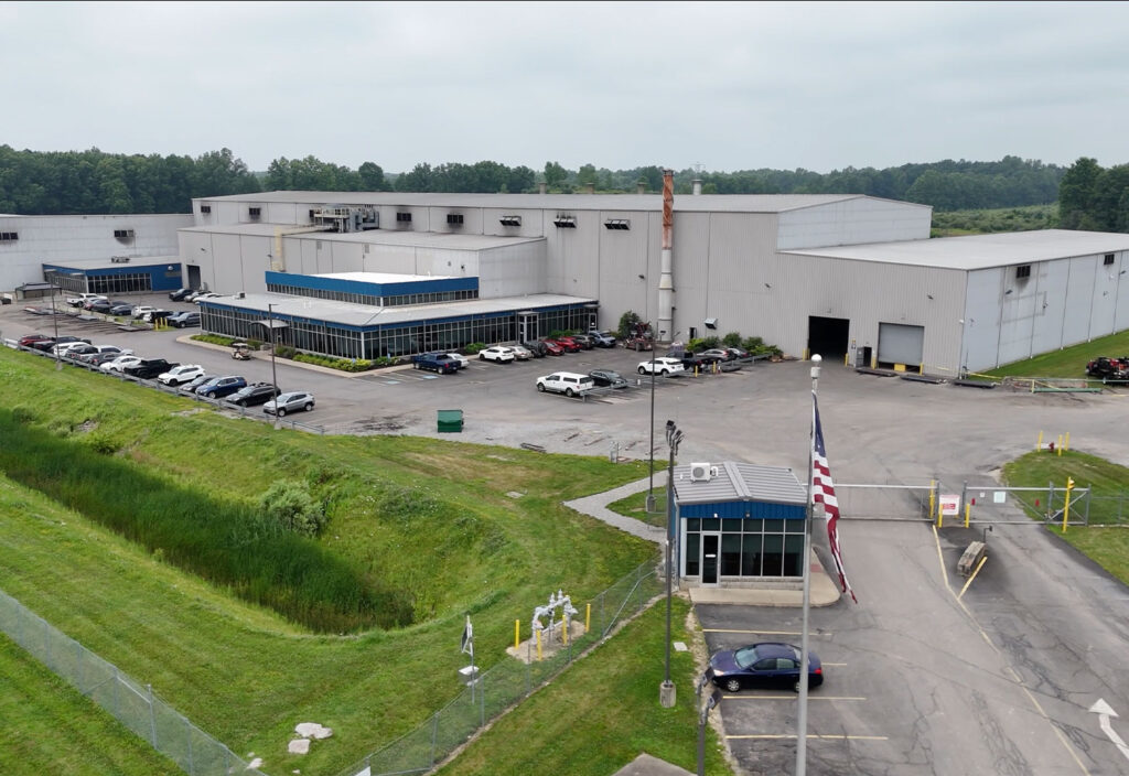 Industrial factory, parking lot with cars and security gate